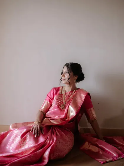 A solo shot of the bride, looking serene and elegant in her draped pink Kanjeevaram saree.