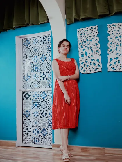 A full-length portrait showing the entire outfit against a vibrant, patterned door in my studio. This demonstrates how we can use different parts of the studio for varied looks.