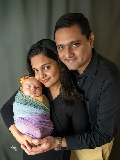 A beautiful family portrait glowing with happiness. The rainbow swaddle adds a lovely pop of color, symbolizing the joy this new baby brings.