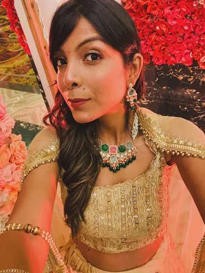 A close-up of a wedding season look. I styled this gold lehenga with a statement necklace that has pops of pink and green, adding a modern touch. I help clients select jewellery and makeup that perfectly complements their outfits.