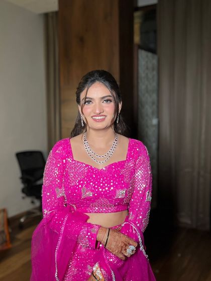 I love when my brides try something new. She chose a modern fish-cut lehenga for her cocktail night, and we paired it with a fun, bright pink makeup look.