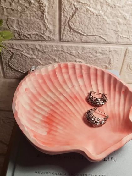 A close-up of our peachy white marble clam shell, perfect for holding a pair of vintage-style earrings.