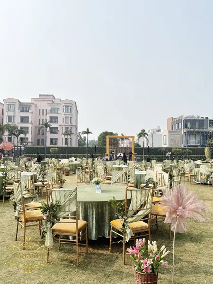 An overview of the guest seating area, with tables covered in pastel green linen and chairs decorated with floral ties.