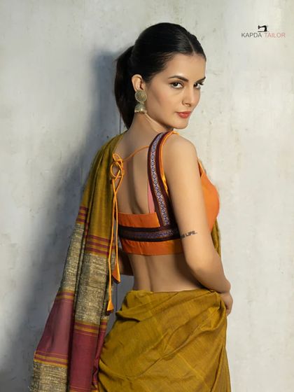 Another look at our Khadi cotton saree, this time showing the beautiful back design of the sleeveless orange blouse. The tie-up detail adds a touch of modern flair to a traditional look.
