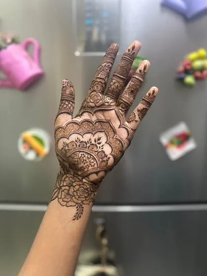 A detailed mandala design on the palm. This style is centered and symmetrical, creating a very balanced and traditional look for festive events.