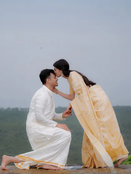A tender moment as the bride-to-be kisses her partner's forehead after his proposal.