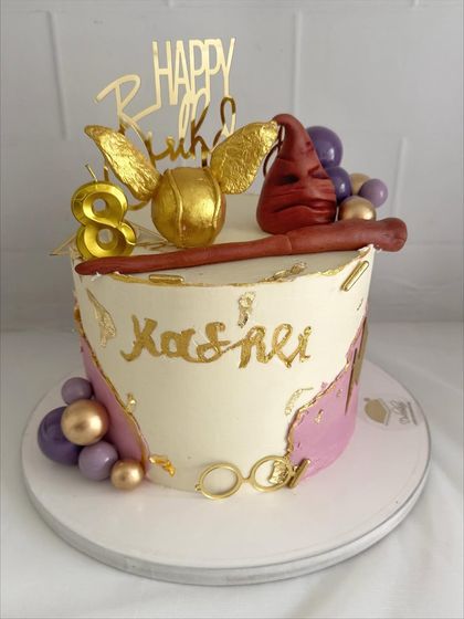 An elegant take on a Harry Potter theme, with a golden snitch, wand, and purple and gold accents.