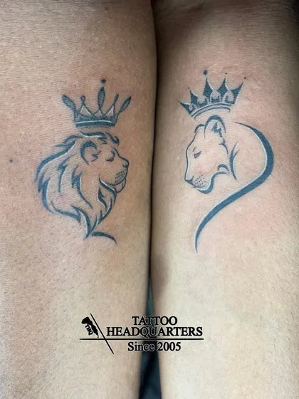A couple's tattoo of a lion and lioness, each wearing a crown, symbolizing a royal partnership.