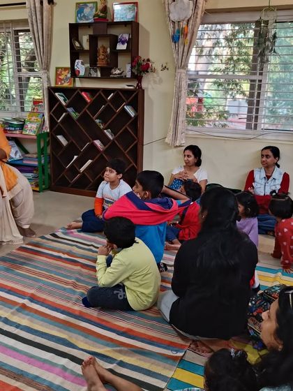The storyteller shows the book's cover, "Angelo," introducing the main character of the day's adventure.