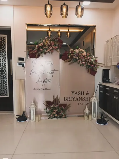 A chic and modern backdrop for a new chapter. This setup uses two-toned panels with custom text, "Time for the next chapter," and is accented with deep red and blush floral arrangements.