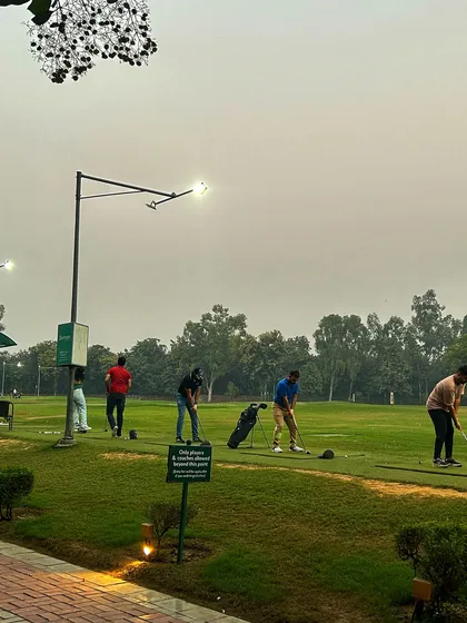 The lights are on and the practice continues for a group of golfers on a cool evening.