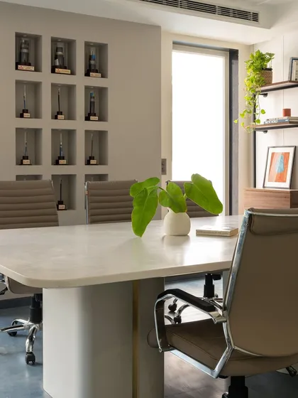 This conference room for Office G-2 in Noida was designed for clarity and focus. We prioritized natural light and a neutral color scheme, creating a bright, professional setting complemented by a custom-built wall niche for displaying company achievements.