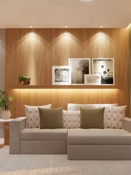 This living room features a comfortable sofa with an ottoman and a floating shelf with backlighting for displaying photos and decor. The design focuses on creating a personal and warm space.