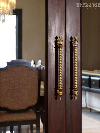 A focused shot of the Chelsea pulls against the rich wood of the door, with the elegant dining room visible in the background.