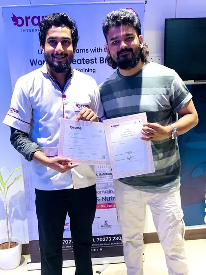 Celebrating student success. Our trainer presents a certificate to a newly qualified hair professional, ready to take on the industry with skills learned at our academy.