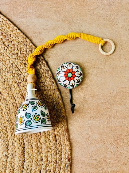 A flat lay of our yellow macrame ceramic bell and a matching hand-painted ceramic hook. You can now choose from a wide variety of combinations and colors to create your own unique set.