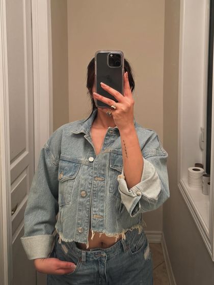 A mirror selfie showing a classic "denim on denim" look. This is a quick and effective way to showcase a trendy, casual outfit combination.