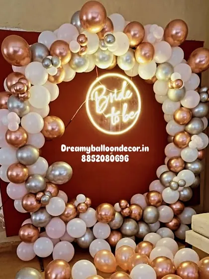 For a chic and modern bachelorette party, I use a stylish neon 'Bride to be' sign as the centerpiece. It's surrounded by a custom balloon ring in rose gold, silver, and white, creating a glamorous backdrop for your celebration.