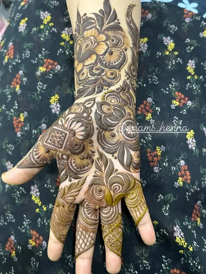 This design shows a beautiful flow from the fingers up the arm. The use of negative space around the main motifs makes the pattern stand out.