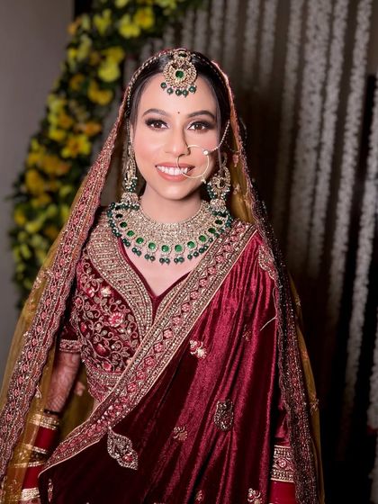 The complete look for Pratibha, with her dupatta perfectly set. The combination of maroon, gold, and green creates a rich and royal color palette.