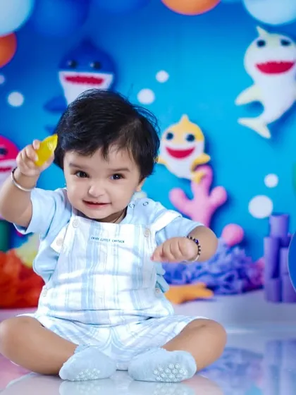 After the cake smash, the birthday boy poses for a clean and cute portrait in his Baby Shark outfit.