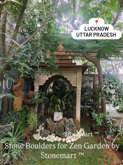 A wider view of a Zen garden we supplied, nestled under the shade of trees and a traditional stone structure. Our boulders and pebbles help transform any corner into a peaceful retreat.