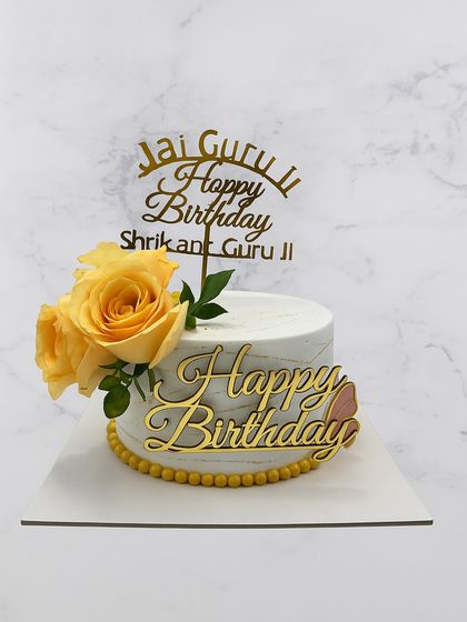 Another one of our elegant Guruji birthday cakes, this one with a marble buttercream finish and fresh yellow roses.