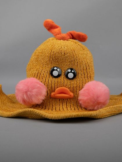 A front view of the mustard-yellow duck hat, showing its cute face.