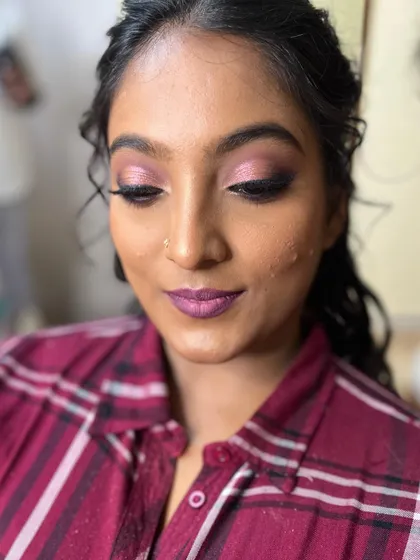 A close-up of Niveditha's reception makeup. We did bold pinkish-lavender eyes and ombre lips to match her saree.