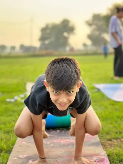 A young student showing off his beautiful Crow Pose, or Bakasana. This is often the first arm balance people learn, and it's a huge confidence booster.