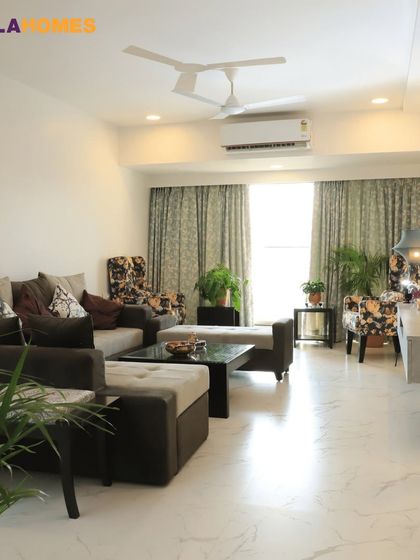 This living room uses earthy tones and plenty of indoor plants to create a relaxing and attentive oasis. The floral-print chairs add a pop of personality.