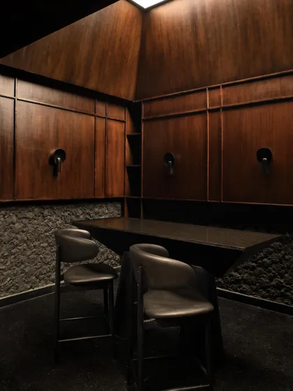 The interplay of materials in the private lounge, with rough stone meeting smooth wood paneling.