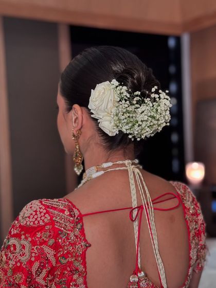 The side view of a floral updo, highlighting the placement of the white rose.