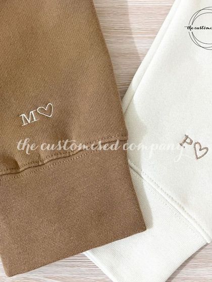 It's the little details that count. These couple's sweatshirts feature subtle, custom-embroidered initials with a heart on the cuff, offering a discreet yet meaningful way to celebrate a connection.