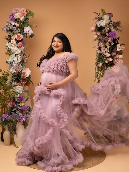 A full-length view of the magnificent ruffled purple gown. The cascading ruffles and flowing train make for a truly show-stopping maternity portrait.
