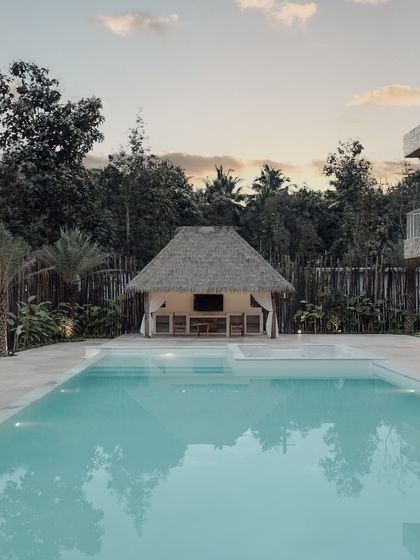 The swimming pool and thatched-roof gazebo are central to the villa's outdoor experience. This space was designed to be a private oasis, perfect for relaxing by the water and enjoying the peaceful ambiance.