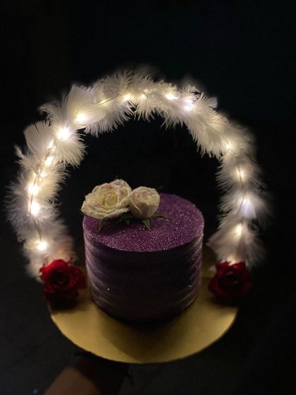 A close-up of the glitter and fresh flowers on our purple hoop cake.