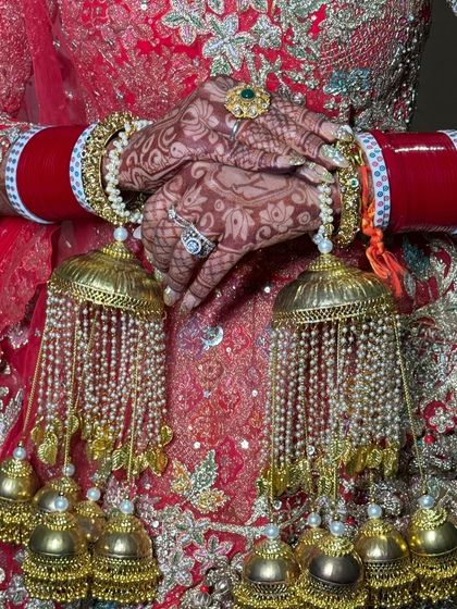 A detailed shot of the bride's hands, adorned with intricate henna and traditional kalire. Every part of the bridal look tells a story.