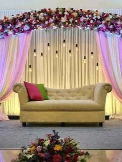 For this reception, the bride requested specific lighting. I used hanging Edison bulbs and soft pink and purple uplighting to complement the floral arch and create a warm, personalized ambiance.