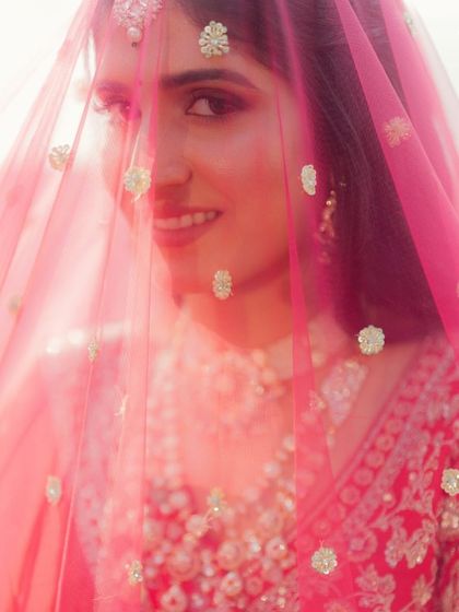 A classic shot through the veil. The makeup is soft yet defined, creating a dreamy and romantic effect.