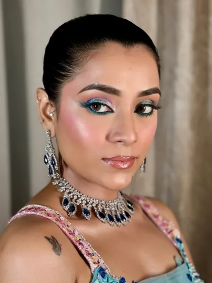 For a modern Mehendi, we can play with color. This look features a vibrant pop of turquoise on the eyes, balanced with glowing skin and a glossy nude lip for a fun yet sophisticated feel.