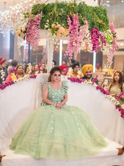 The grand entrance on a beautifully decorated palanquin. Her makeup is designed to make her look like royalty.