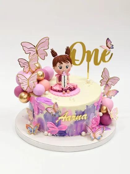 A single-tier version of the butterfly cake, featuring a similar girl figurine, butterflies, and a "One" topper.
