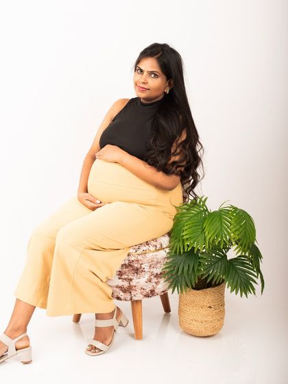 A chic and modern studio maternity portrait. The simple white background and minimalist styling put all the focus on the expectant mother's confident and beautiful pose.
