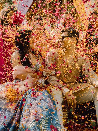 A wider view of the petal shower, capturing the full, beautiful chaos of the moment as the couple is blessed with flowers and love.