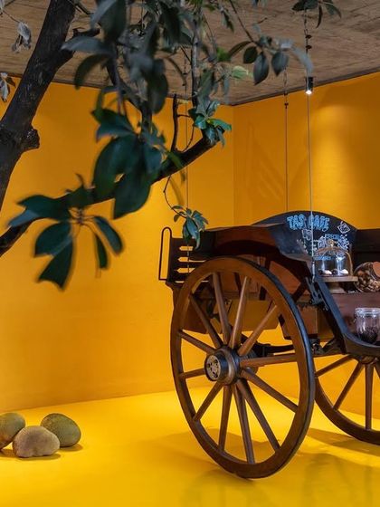 The 'Tonga Court Cafe' at our Belagavi studio, where a restored antique horse cart is repurposed as a bar against a vibrant ochre wall. This space is a playful nod to local heritage and serves as a unique social hub for our team and visitors.