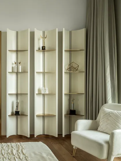 This shot focuses on the custom-designed shelving units in the green bedroom. The curved, free-standing design allows for flexible decor and display, adding an artistic flair to the space.