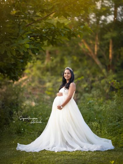 A beautiful portrait in a white gown, with the soft light and green foliage creating a fairytale-like atmosphere.