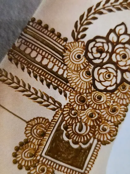 A close-up on the wrist portion of the design, showing a beautiful combination of floral and leafy patterns.