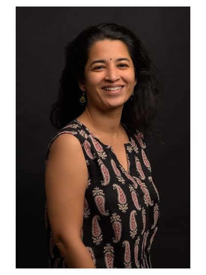 A color version of a studio portrait, showing a bright and happy expression against a simple black backdrop.